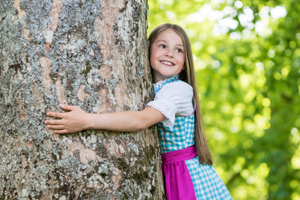 Mädchen klammert sich um einen Baum